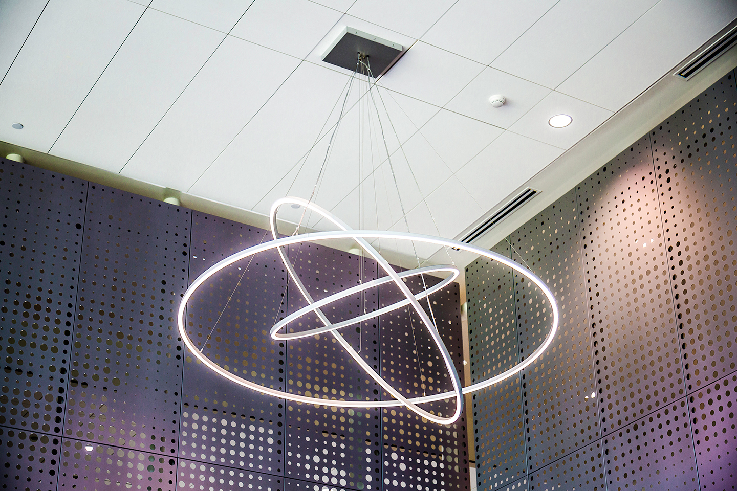 A sun-inspired lighting fixture provides a focal point in the center. Internal and exterior murals cover three sides of the building, catching the sunlight and creating the illusion of comets moving through the cosmos.