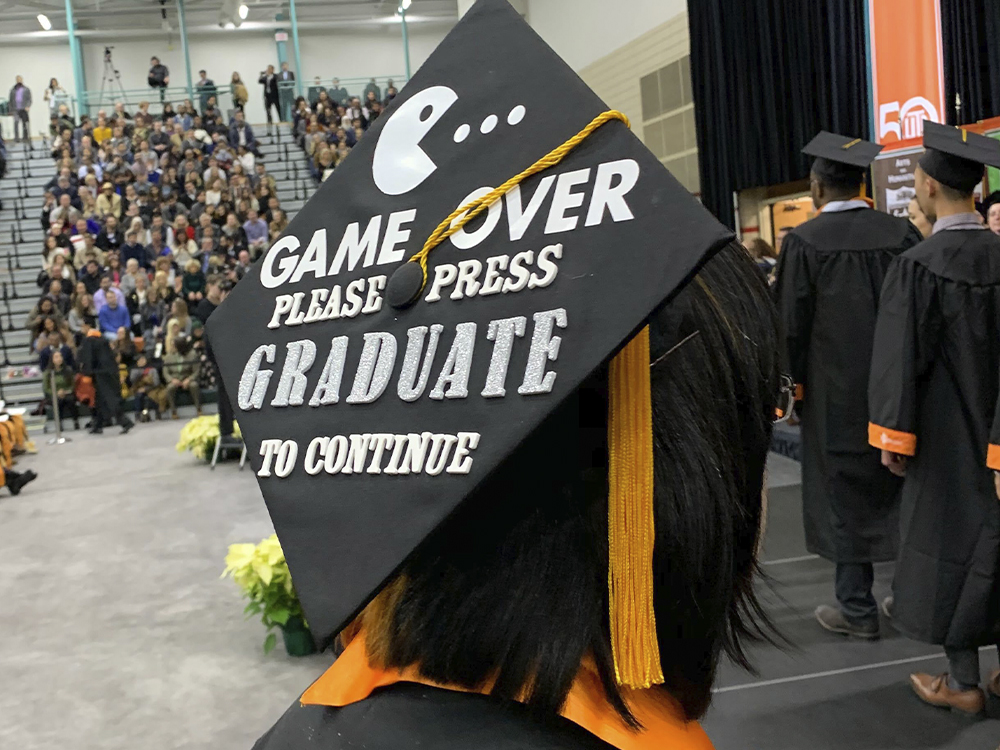 Woman wearing a cap that says game over, please press gradute to continue