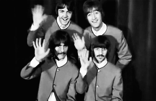 The Beatles wave at the camera then look confused