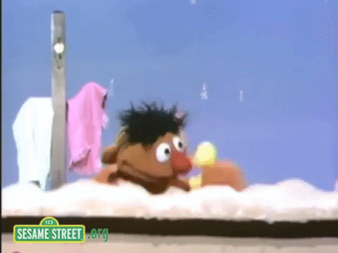 Ernie from Sesame Street with a rubber duck in a bathtub