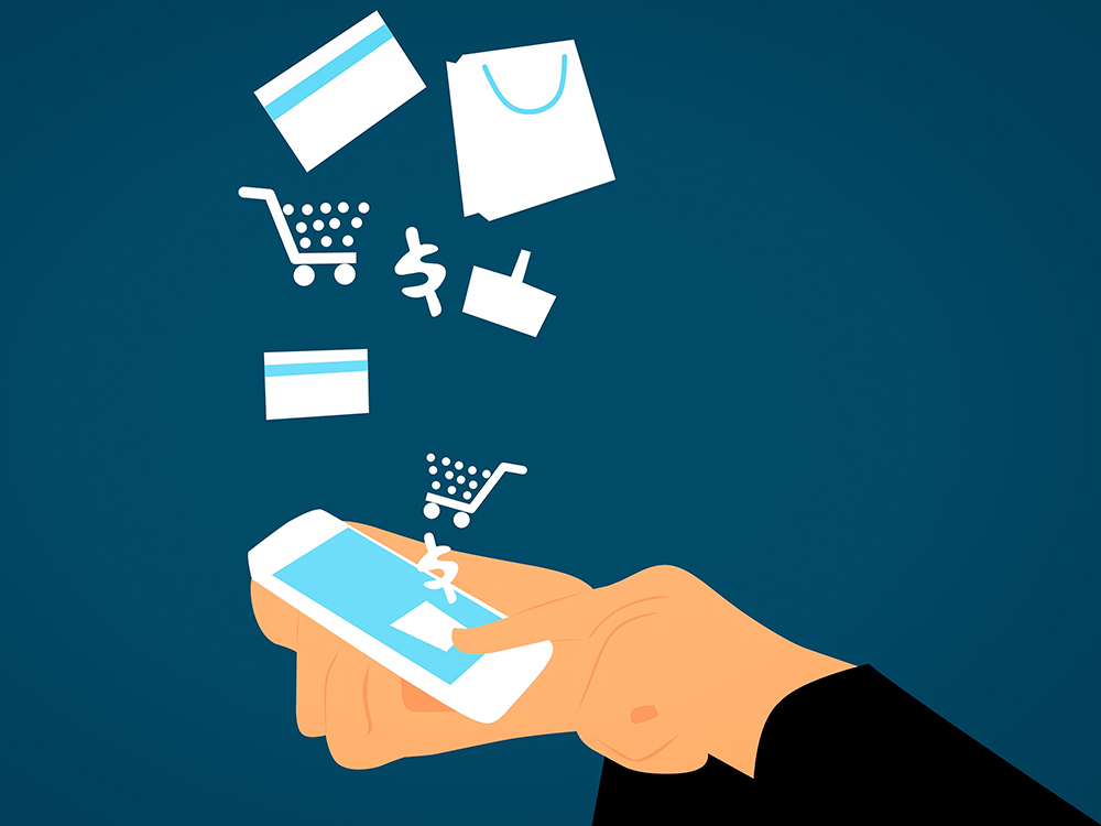 An illustration with a hand holding a phone and shopping icons coming out of it.