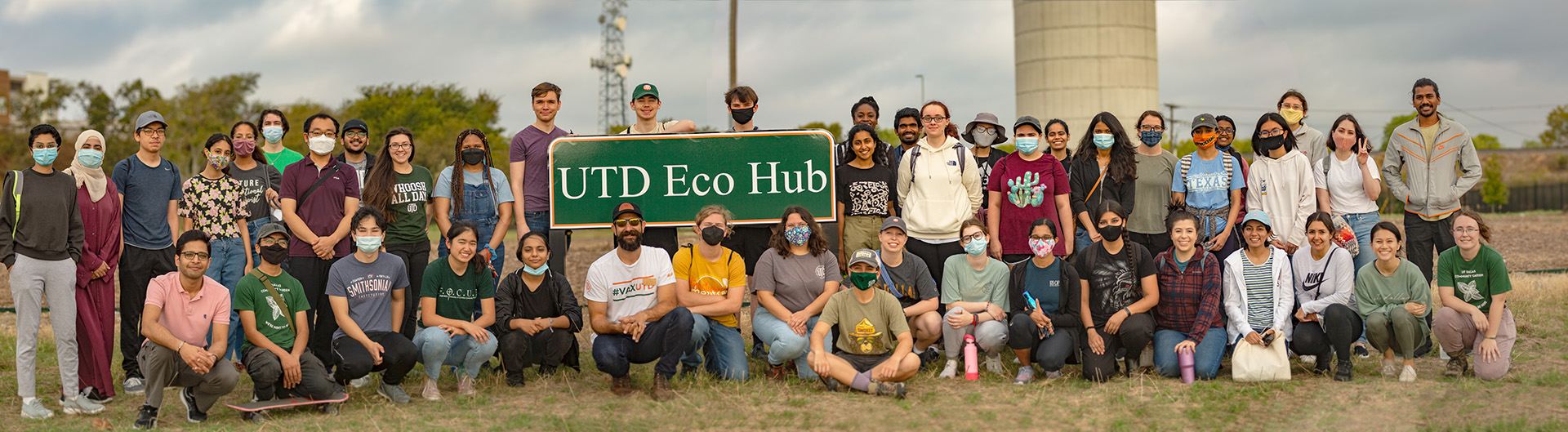 Dozens of Eco Hub students gathered around a green UTD Eco Hub sign. 