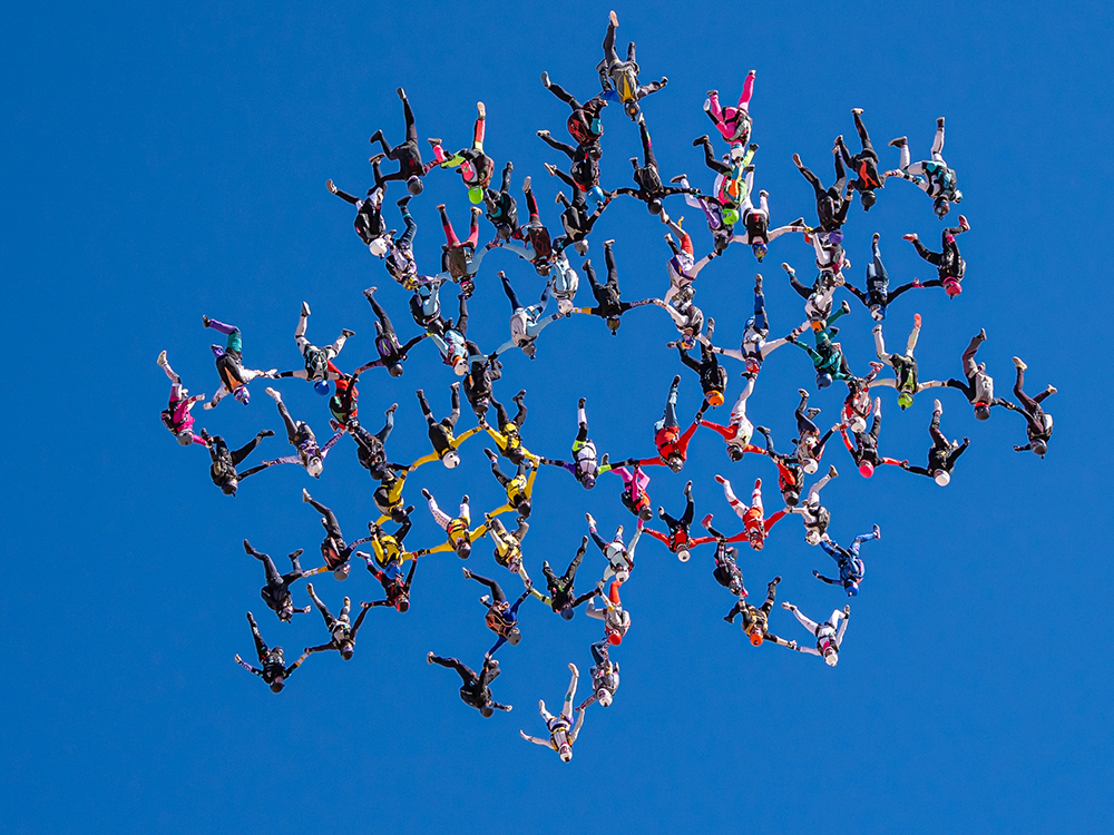 About 80 skydivers in the middle of a jump