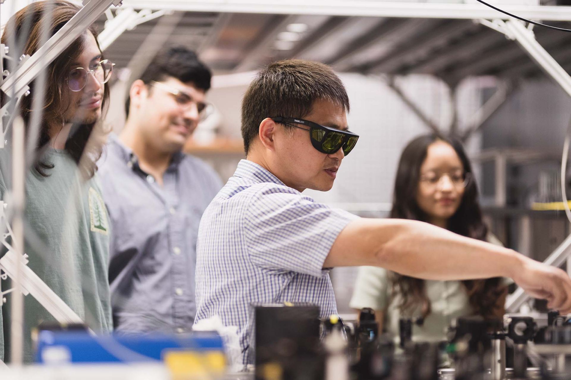 Dr. Shengwang Du (center) aligns laser beams used to trap and cool rubidium atoms to ultra-cold temperatures. Members of Du’s research group include, from left, undergraduate physics students Lennon Kirby and Sean Smith, and doctoral student Manshuo Lin. Other members of Du’s lab (not pictured) include doctoral students Christopher Li, Alan Zanders BS’18, MS’20 and Xuanying Lai.