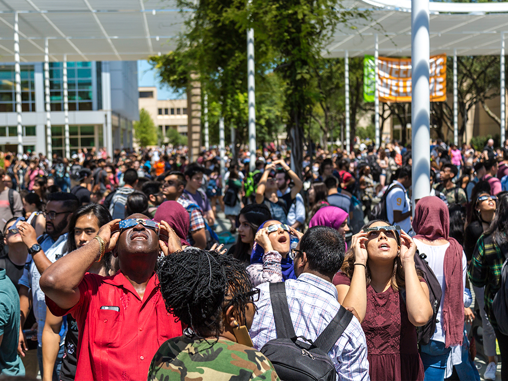 Members of the UT Dallas community observe a solar eclipse on the Plinth